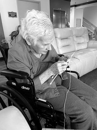 A patient seated in a wheelchair in her living room