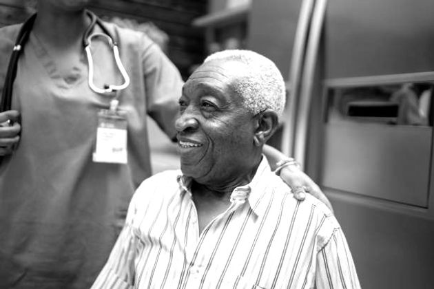 A patient smiling alongside a home care nurse
